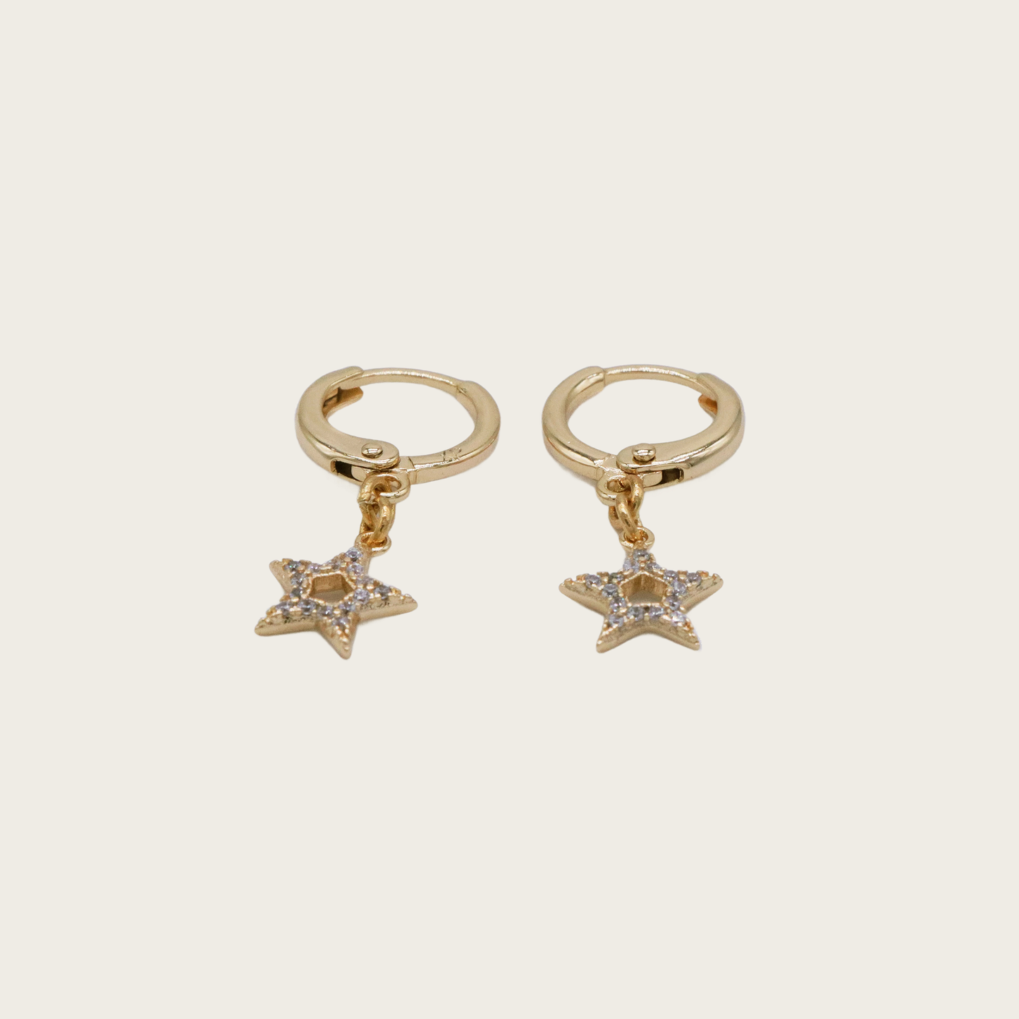 Delicate 14K gold huggie hoop earrings with a mini dangling star charm
