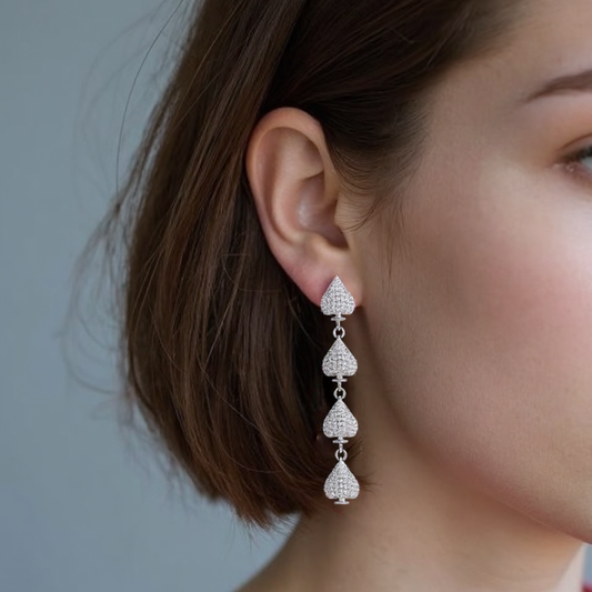 Gold plated asymmetric heart dangle earrings with zircon clusters, showcasing one solid heart and one clustered heart design on a model.