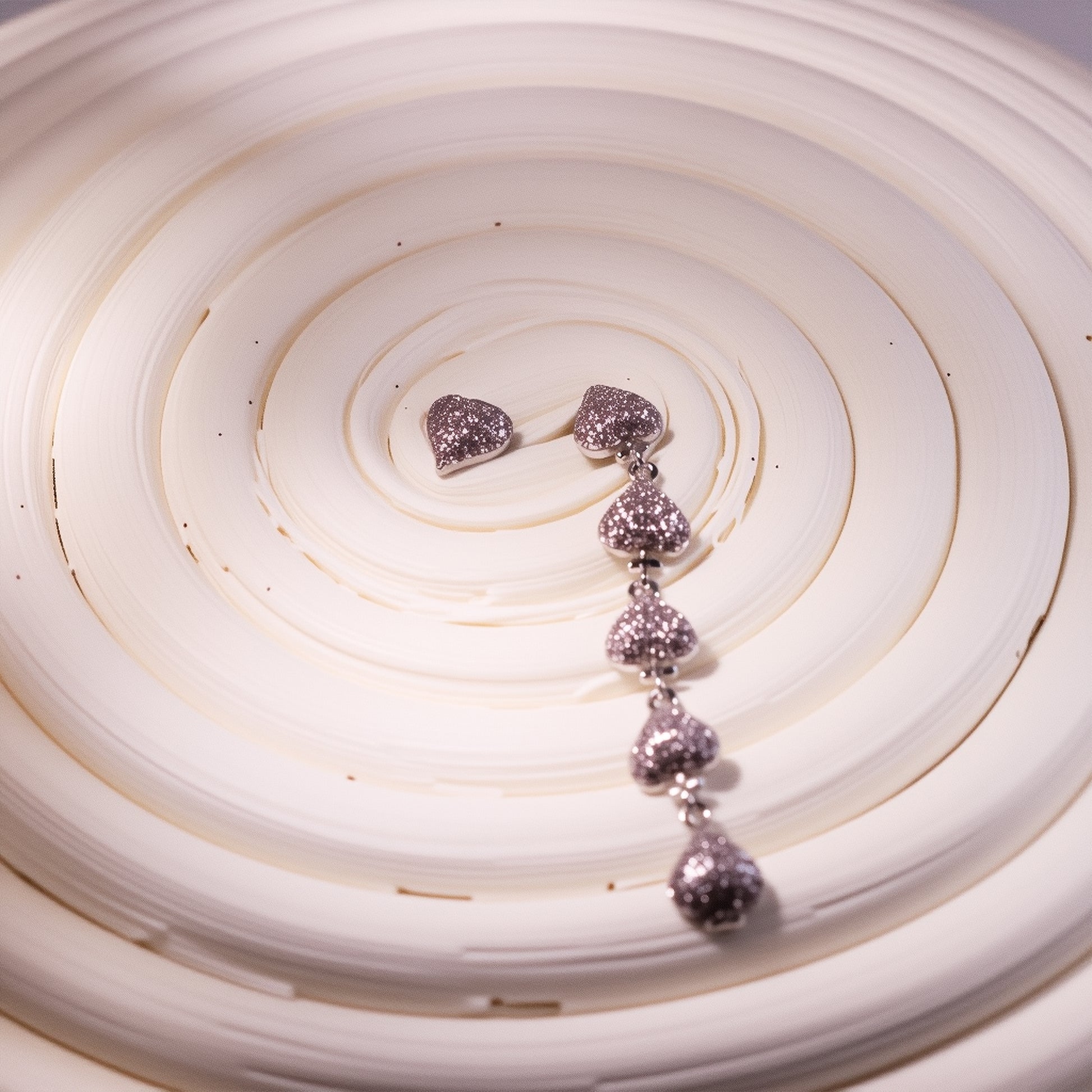 Gold plated asymmetric heart dangle earrings with zircon clusters, showcasing one solid heart and one clustered heart design on a model.