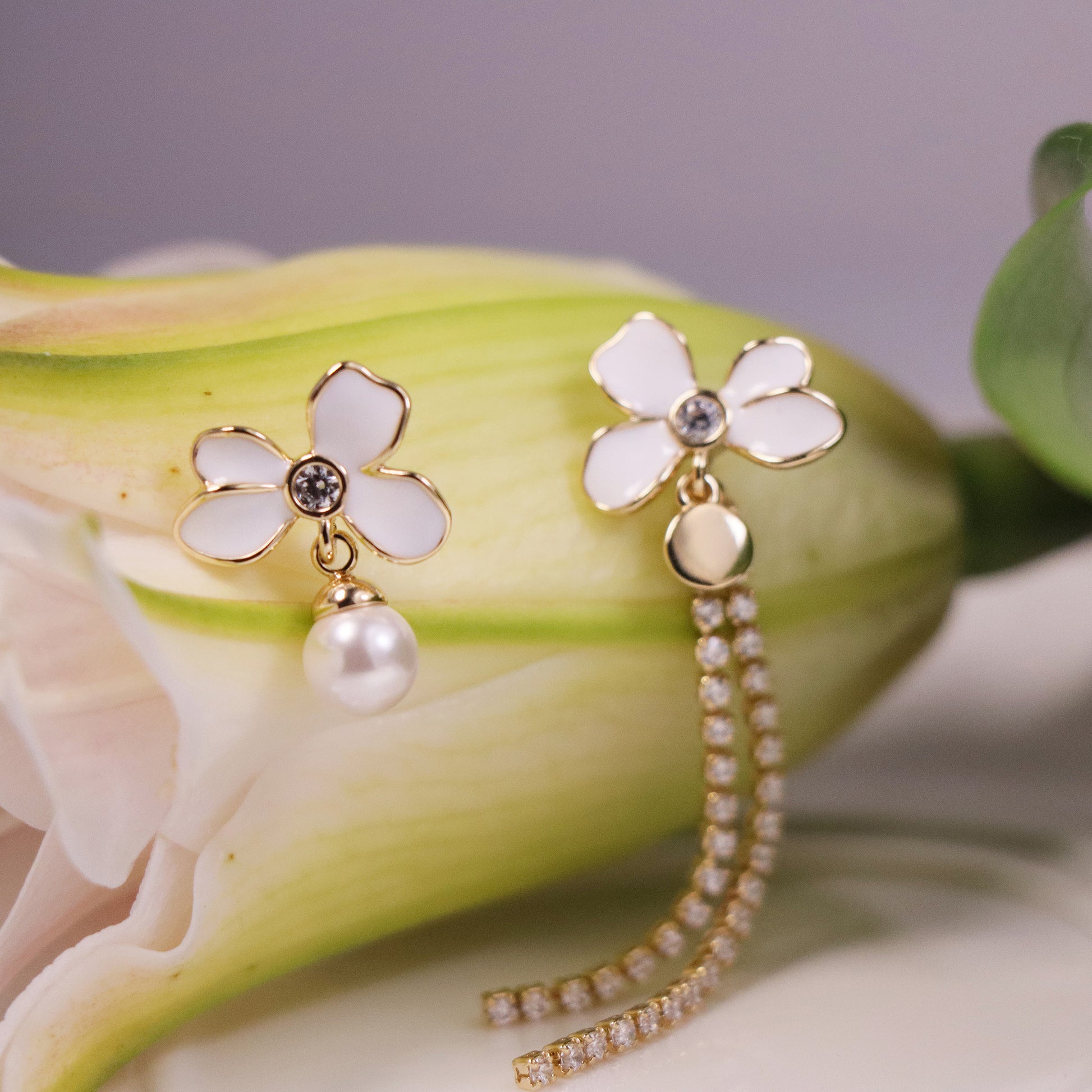 Gold plated asymmetric earrings with one floral cluster and one silk tassel