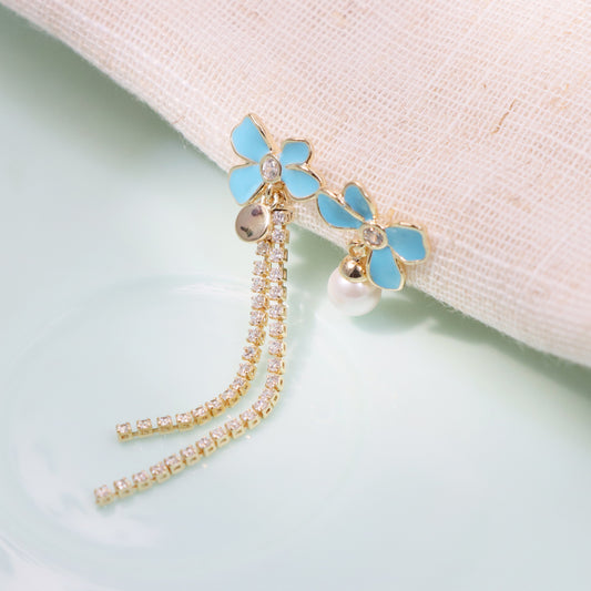 Gold plated asymmetric earrings with one floral cluster and one silk tassel
