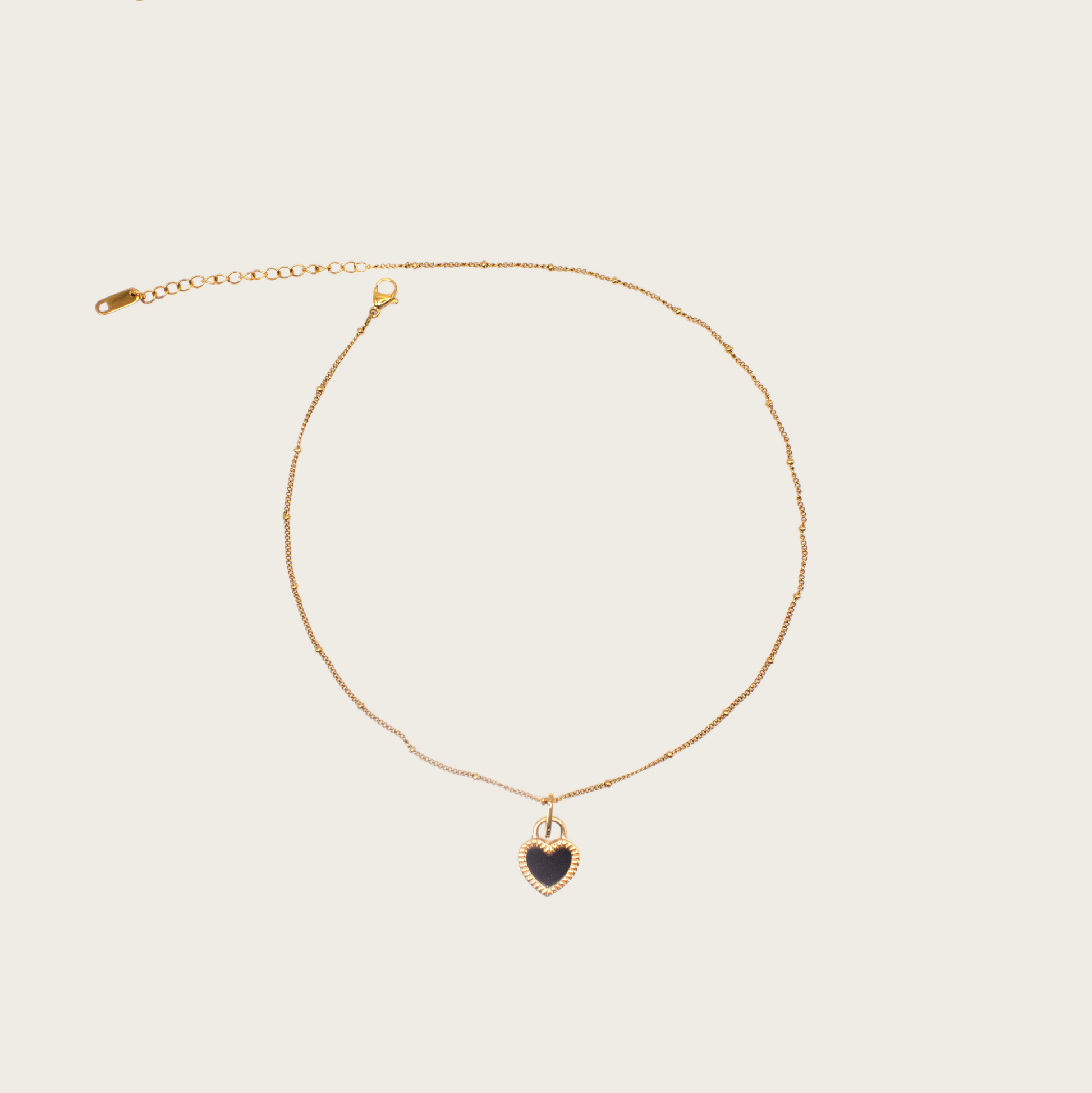 Delicate gold chain necklace with small textured heart pendant