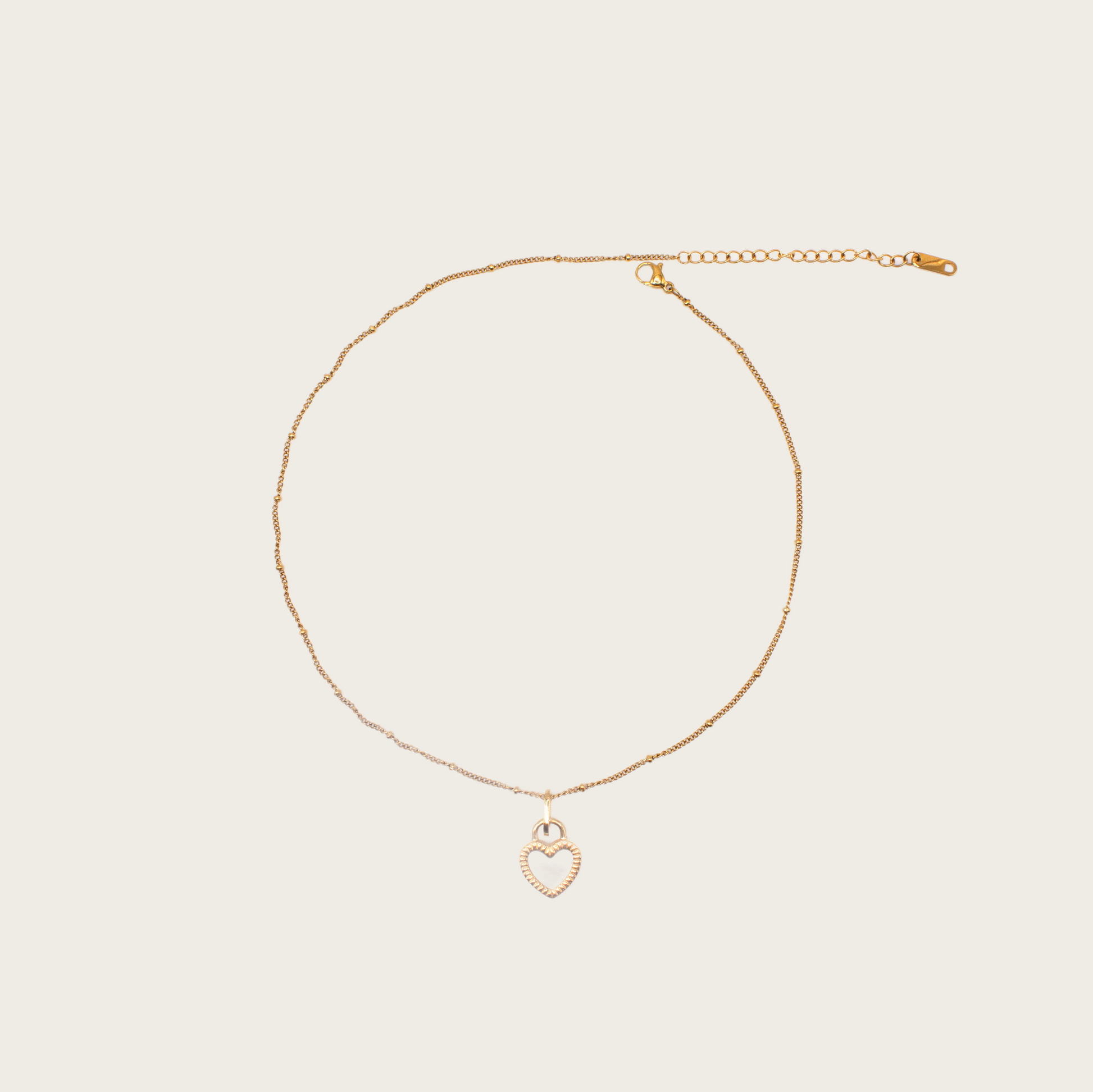 Delicate gold chain necklace with small textured heart pendant