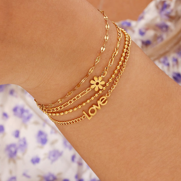 Figaro chain bracelet with daisy charm accents
