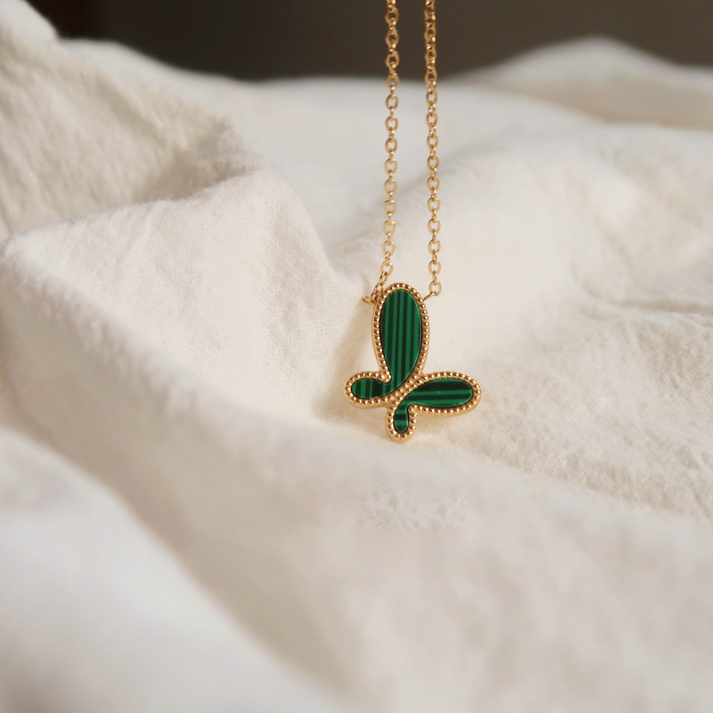 Charming green butterfly pendant necklace, nature-inspired.