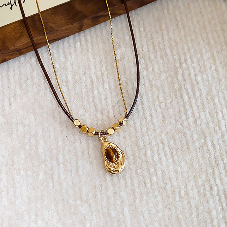 Handmade necklace featuring green tigerite beads strung on a natural cord