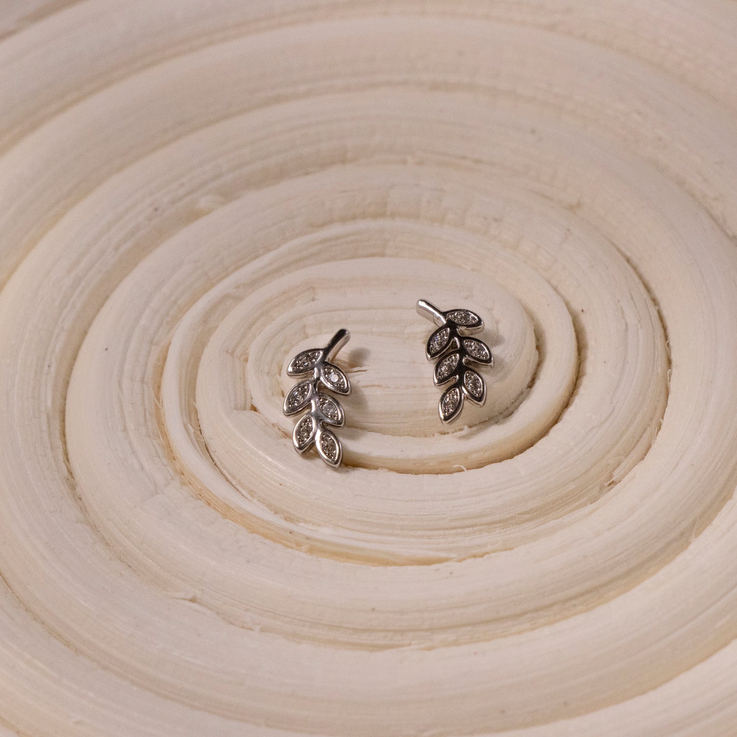 Tiny sterling silver leaf stud earrings with intricate detailing
