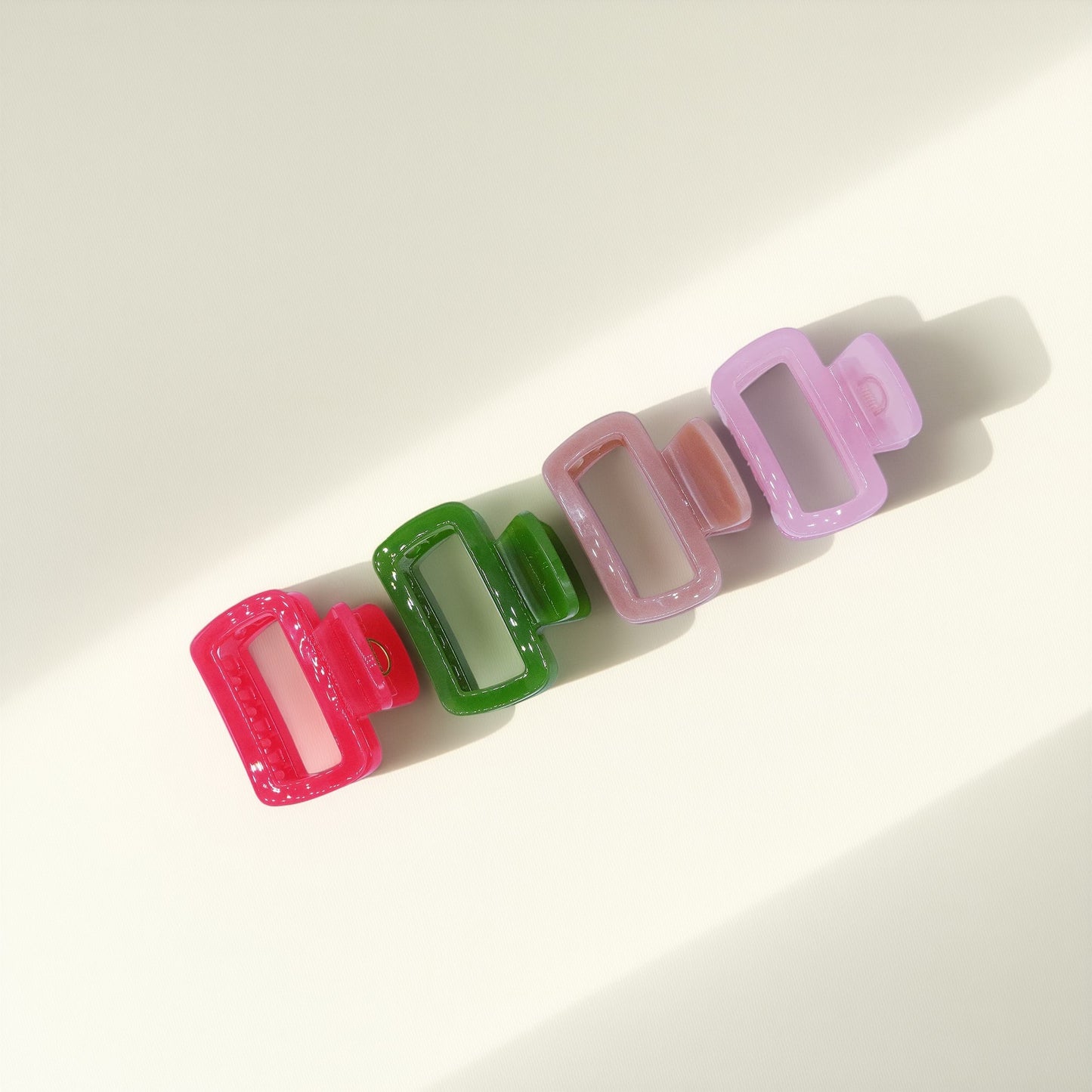 Set of pastel-colored rectangular hair claw clips in pink, mint, and lavender, styled on a wavy half-up hairstyle.