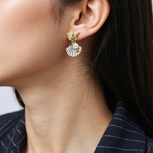 Delicate starfish earrings featuring a pearl drop.