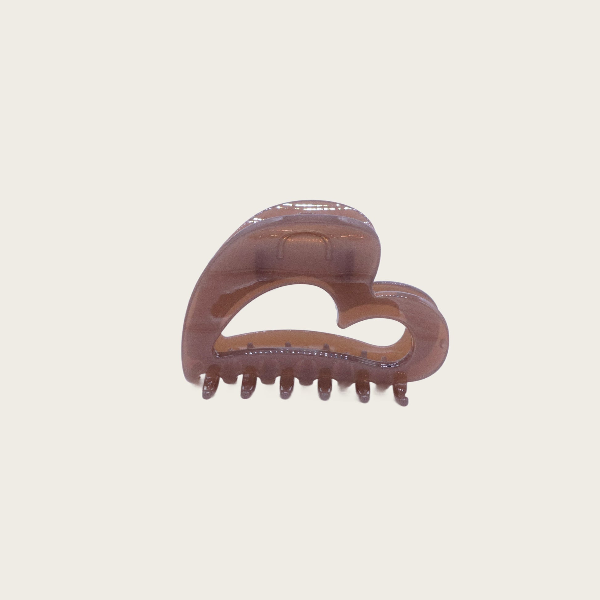 Clear acrylic heart-shaped claw clip holding a twisted half-up hairstyle, styled on blonde wavy hair.