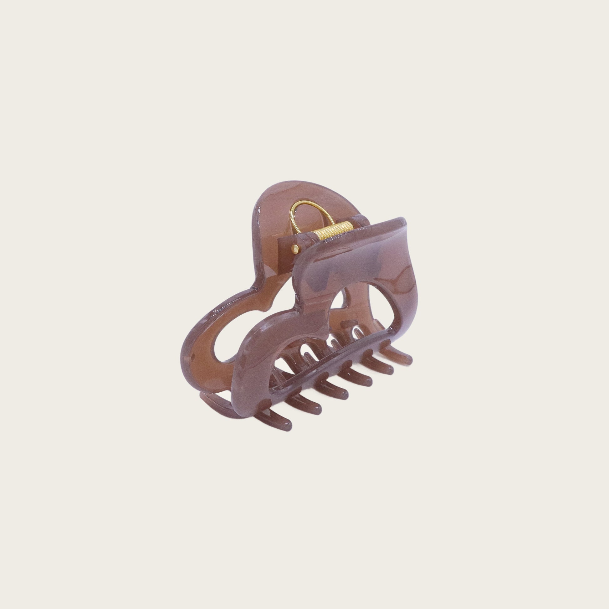 Clear acrylic heart-shaped claw clip holding a twisted half-up hairstyle, styled on blonde wavy hair.